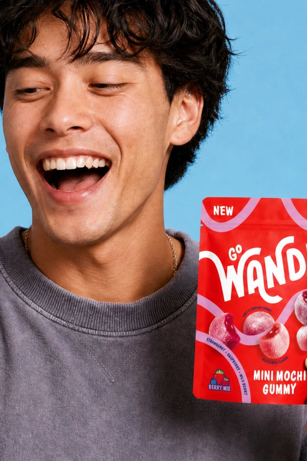 a man laughing while holding Go Wandr mini mochi gummies