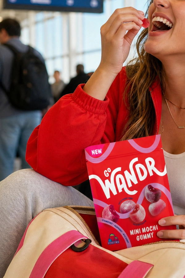 woman in red jacket holding Go Wandr mini mochi gummies